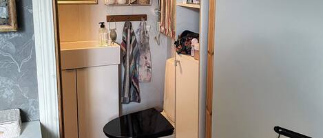 A compact bathroom with a toilet, a sink, and a shower area.