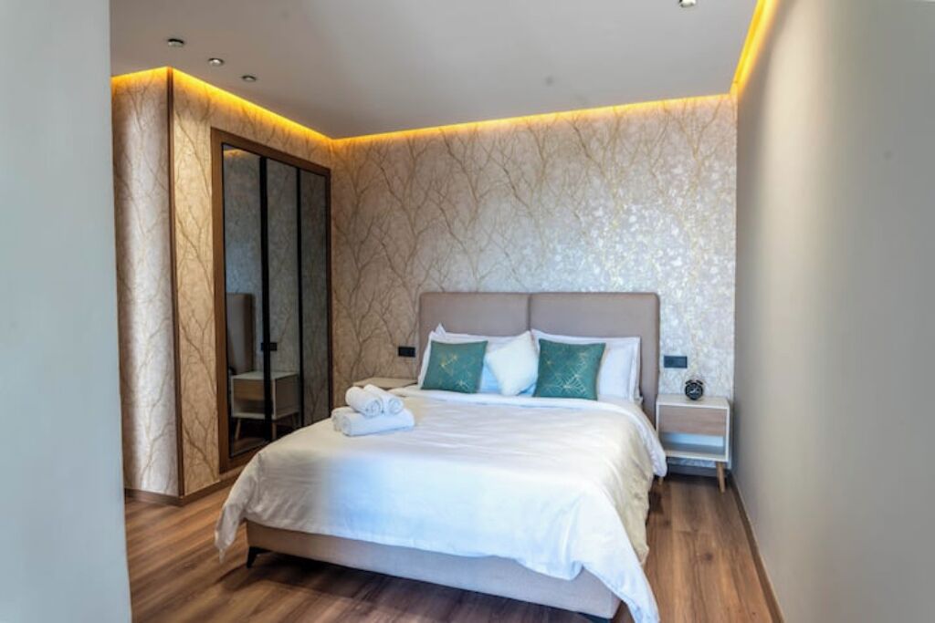A modern bedroom with a bed, bedside table, and a wardrobe.
