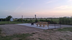 An outdoor area with a picnic table, a water tower, and a fenced field. - 1 or 2 Wonderful private RV spots,full hookups. 5 min walk to beach on Bolivar (Bolivar Peninsula)