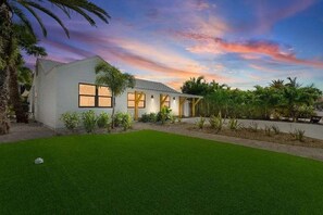 A modern house with a well-maintained lawn and a clear sky.