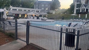 Zona de piscina con sillas de descanso y una valla.