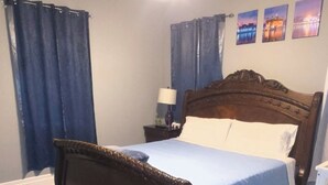 Una camera da letto con un letto di legno, una ventola a soffitto, un comodino e una lampada.