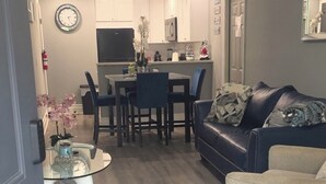 Un soggiorno moderno con angolo pranzo, divano e televisione.