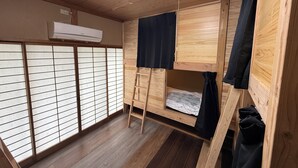 A room with a bunk bed, a ladder, a futon, sliding shoji doors, and an air conditioning unit. - BungonoSato (Kusu)