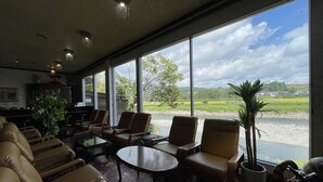 A spacious room with large windows, leather sofas, a coffee table, and a potted plant. - BungonoSato (Kusu)