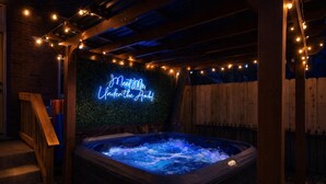 Ein Whirlpool mit einem Neonlichtschild, auf dem 'Feel the Heat Under the Arch' steht.