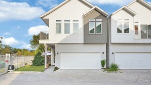 Ein zweigeschossiges Wohnhaus mit Garage, überdachter Eingangsparte und einem eingezäunten Hinterhof.