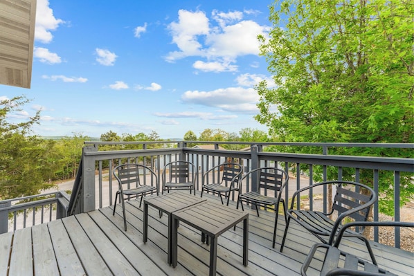 A deck with a table and chairs, overlooking a natural landscape. - Peaceful Lodge Minutes to Silver Dollar City & Indian Point Marina_Free Attraction Tickets_Cmty Pool (Branson)