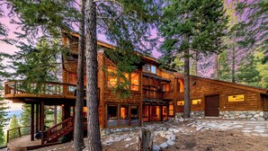 A multi-level wooden cabin with a stone foundation, large windows, and a deck. - Lx16 Luxe Martis Landing Sauna, Gameroom and Hot Tub (Truckee)