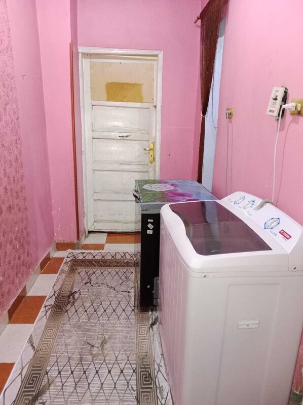 A laundry room with a washing machine, a dryer, and a door.