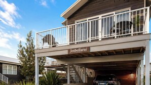 A two-story building with a balcony and a garage. - Jesbellerai Villa- Caves Beach Resort (Caves Beach)