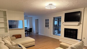 Ein Wohnzimmer mit Kamin, Fernseher und Essbereich.