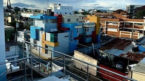 A residential area with colorful buildings, a swimming pool, and a view of the cityscape. - Room-hotel Maria Bonita Higüey 2 (Higuey)