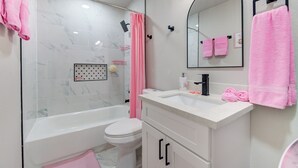 Un bagno con vasca, servizi igienici e mobile lavabo con specchio.