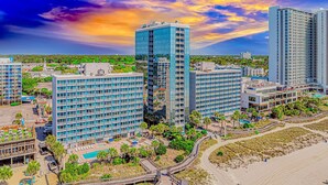 A high-rise hotel with multiple floors, a swimming pool, and a beach area. - Yachtsman S502 Studio (Myrtle Beach)