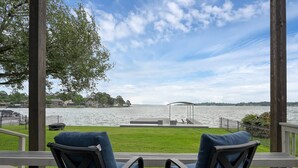 A deck with two chairs facing a lake, a gazebo, and houses in the background. - 5BR Lake Conroe Waterfront | 3 Kings + Private Dock | Swim + Fish | Games + Fire Pit | Sleeps 12 (Montgomery)