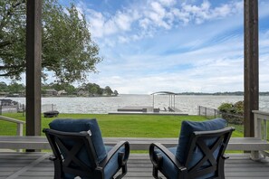 A deck with two chairs facing a lake, a gazebo, and houses in the background. - 5BR Lake Conroe Waterfront | 3 Kings + Private Dock | Swim + Fish | Games + Fire Pit | Sleeps 12 (Montgomery)