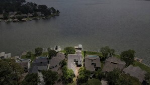 A residential area with houses near a large body of water, a dock, and a swimming pool. - 5BR Lake Conroe Waterfront | 3 Kings + Private Dock | Swim + Fish | Games + Fire Pit | Sleeps 12 (Montgomery)