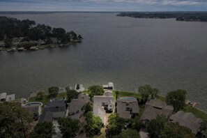 A residential area with houses near a large body of water, a dock, and a swimming pool. - 5BR Lake Conroe Waterfront | 3 Kings + Private Dock | Swim + Fish | Games + Fire Pit | Sleeps 12 (Montgomery)