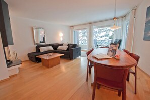 A modern living room with a sofa, coffee table, dining table, and chairs. - Villa Emeline, Apartment Lora (Zermatt)