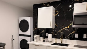 A modern kitchen with a marble backsplash, built-in appliances, and a kitchen island. - Velvet Desire Only For adults/ 15 min Strip (Las Vegas)