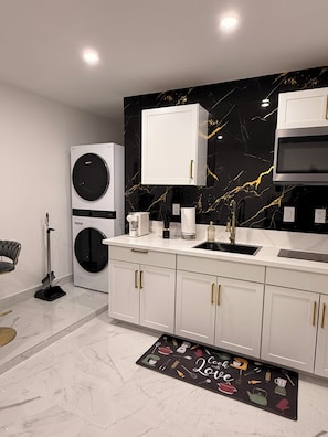 A modern kitchen with a marble backsplash, built-in appliances, and a kitchen island. - Velvet Desire Only For adults/ 15 min Strip (Las Vegas)