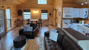 A cabin interior with a living room, dining area, kitchen, and a ceiling fan. - 
Misty Spruce, tucked away, wooded for 2 guests. Honeymoon/Anniversary/Birthdays (Gatlinburg)