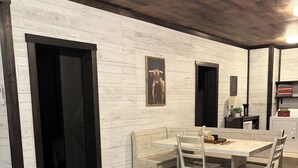 A dining area with a table and chairs, a bench, and a wall-mounted picture.