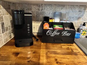 A coffee maker, a coffee bar box with coffee packets, and a hand soap dispenser on a kitchen counter. - Cozy 2-bedroom house in  McAlester.  Close to hospital and shopping. (McAlester)