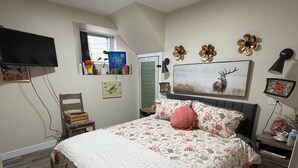 Una camera da letto con un letto, una televisione, una finestra e una porta.