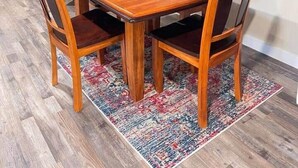 A dining room with a wooden table, four chairs, a patterned rug, and framed pictures on the wall. - Charming Bed & Breakfast! 2 (Estevan)