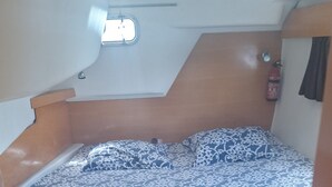 A compact room with a bed, a small cabinet, and a window. - Shared catamaran anchored in anse mitan bay at trois ilets (Les Trois-Îlets)