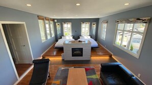 A spacious room with a fireplace, two beds, a seating area, and large windows. - Tabinoteitaku Kamakura Yuigahama (Kamakura)