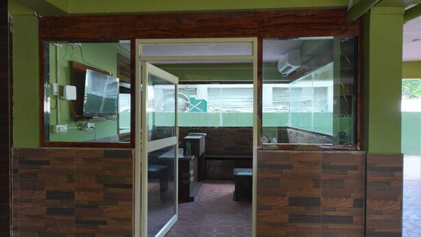 A room with a tiled floor, a wooden-framed door, and a view through a glass partition. - Hotel Elite premium (Puri)