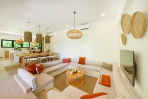 A modern living room with a sofa, coffee table, and dining area.
