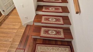 Eine Treppe mit Holzbodenstufen und gemusterten Teppichen.