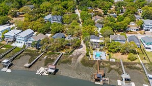 Una vista aerea di una zona residenziale costiera con case, un molo e una piscina.