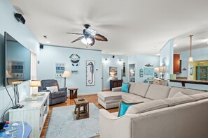 A living room with a ceiling fan, a sofa, a coffee table, and a TV. - Small Dog(s)|Spa|Arcade|2 Kitchens (By Beach Star) (Murrells Inlet)
