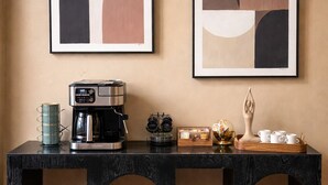 A room with a black marble coffee table, two abstract paintings, a coffee machine, and a tray with cups and a teapot. - Elegant 4BDR Boston Stay Free Garage + EV Charger (Boston)
