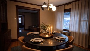A round dining table with candles, plates, and cutlery, set in a room with a view through a window. - Elegant 4BDR Boston Stay Free Garage + EV Charger (Boston)
