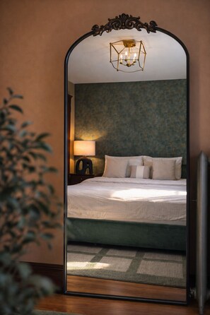 A bedroom with a bed, a nightstand, a lamp, and a mirror. - Elegant 4BDR Boston Stay Free Garage + EV Charger (Boston)