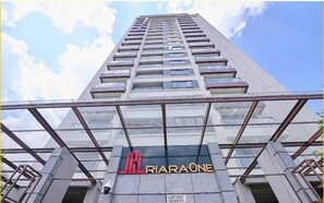 Ein hohes Gebäude mit Glasfassade und einem Schild mit der Aufschrift 'RIRAONE' am Eingang.