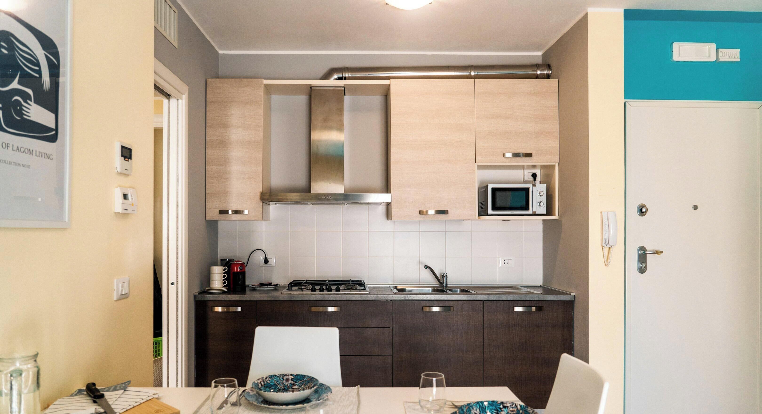 A modern kitchen with dark cabinets, a microwave, and a gas stove.