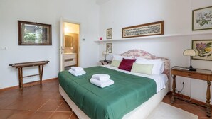 Un dormitorio con cama, mesita de noche y ventana.