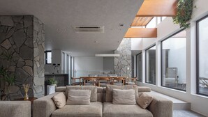 Ein modernes Wohnzimmer mit einer Couch, einem Couchtisch und einem Essbereich mit Tisch und Stühlen.