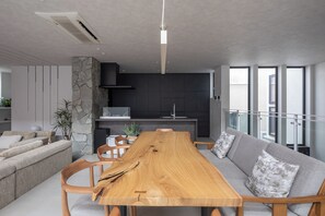 A modern living space with a dining table, sofa, and kitchen area. - Entire Sapporo Villa | Private Sauna & Outdoor Bath | 10 Guests | 2 Free Parking (札幌市東区北２５条東２丁目)