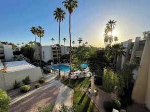 A hotel with a swimming pool surrounded by palm trees and a clear sky. - Modern and Sophisticated Old Town Scottsdale Gem (Scottsdale)