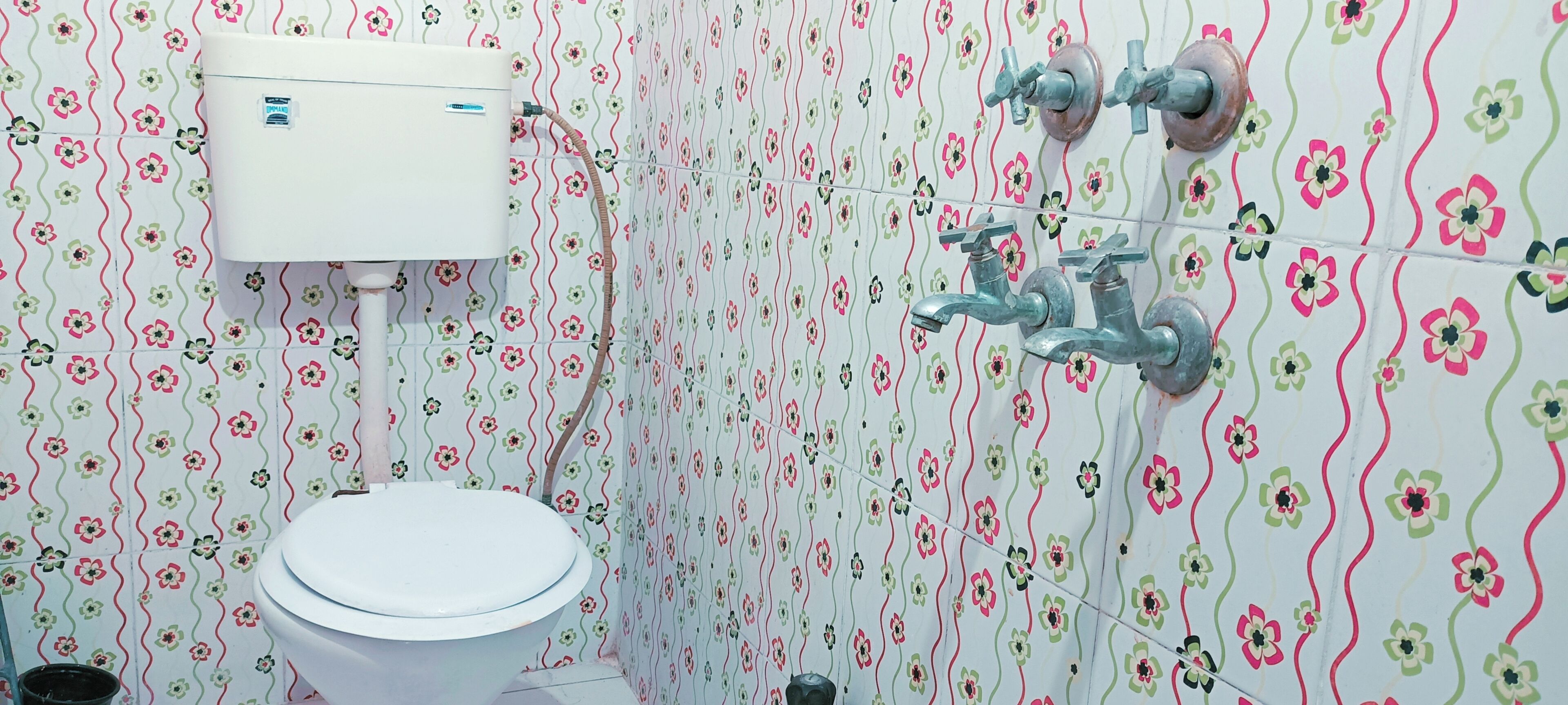 Une salle de bain équipée de toilettes, d’un réservoir d’eau et d’un robinet.