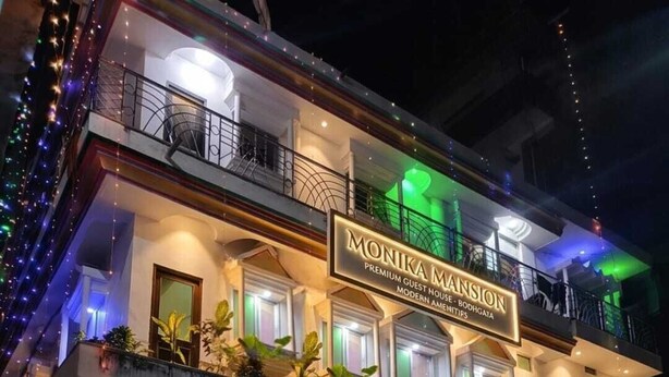 A hotel named 'Monika Mansion' with a modern design, a gated entrance, and a balcony with plants. - MONIKA MANSION BODHGAYA (Bodh Gaya)