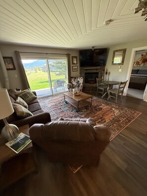A living room with a sofa, coffee table, and a fireplace. - The Perfect Big Sky Getaway (Big Sky)